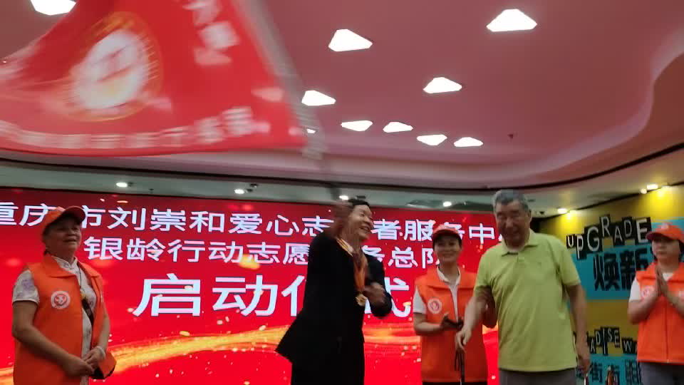 刘崇和总队长从市委老领导手中接过银龄总队的旗子